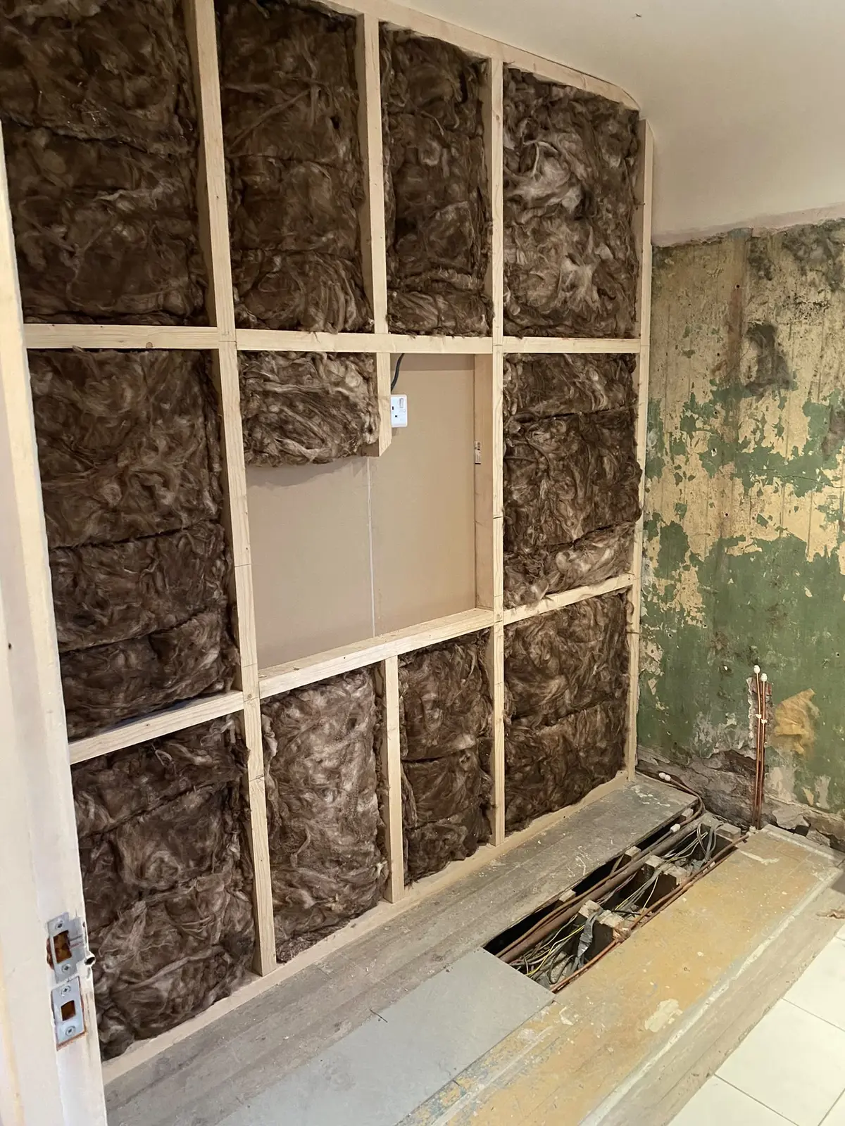 Stud wall insulated and framed for an alcove