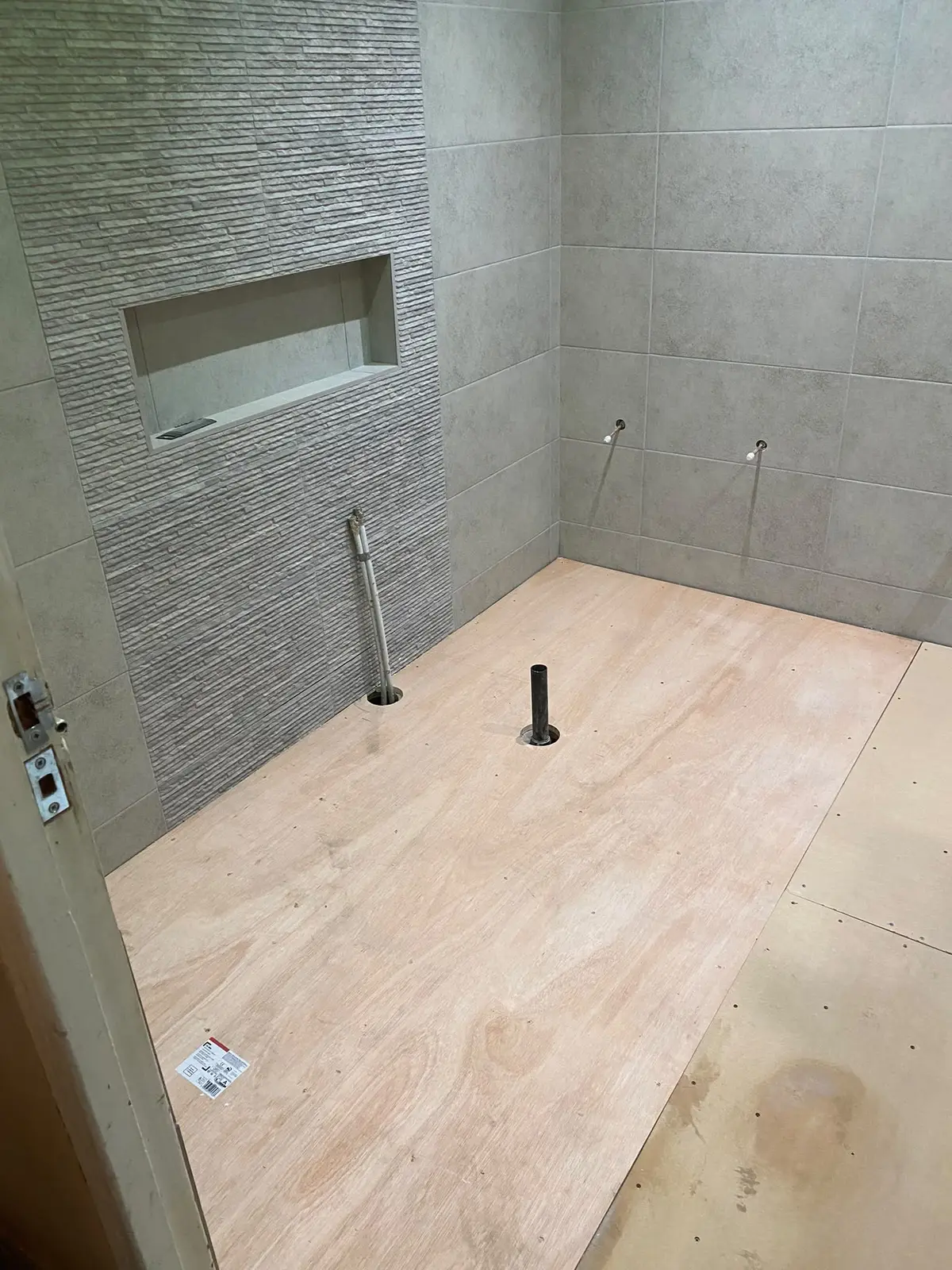 Walls tiled, with a recessed alcove above where the bath goes