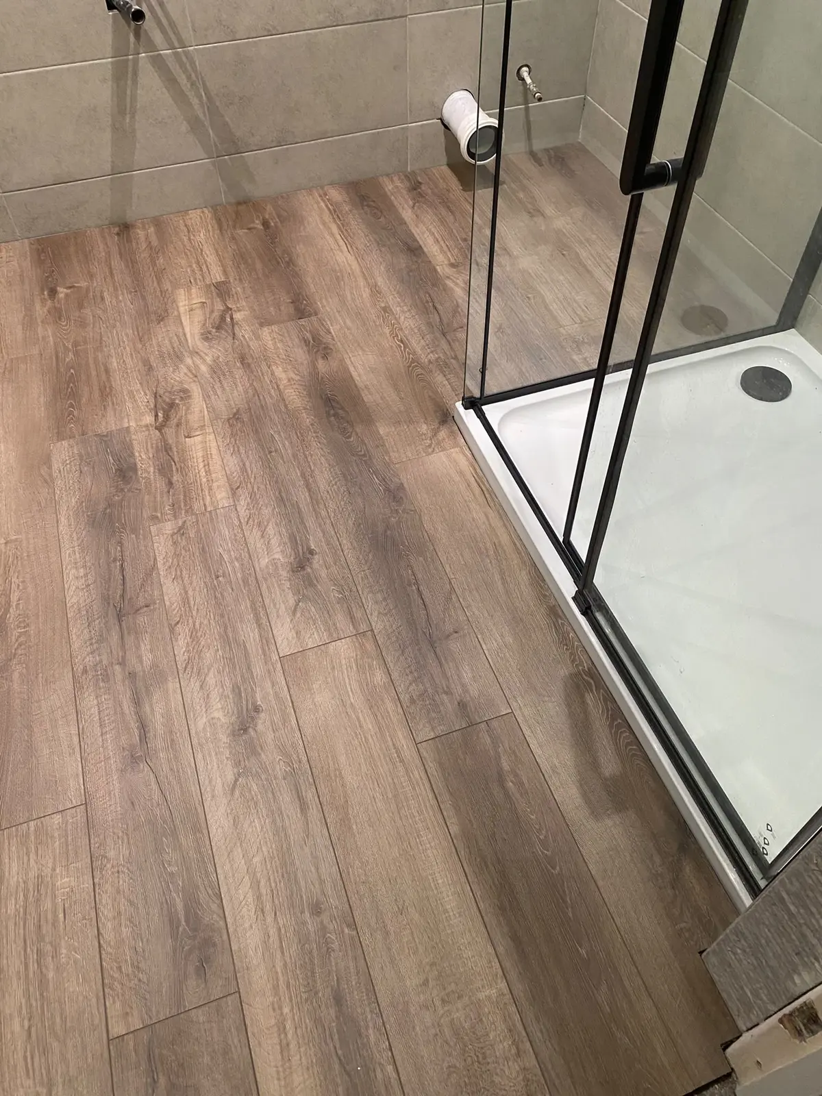 Oak LVT flooring laid beside the shower enclosure