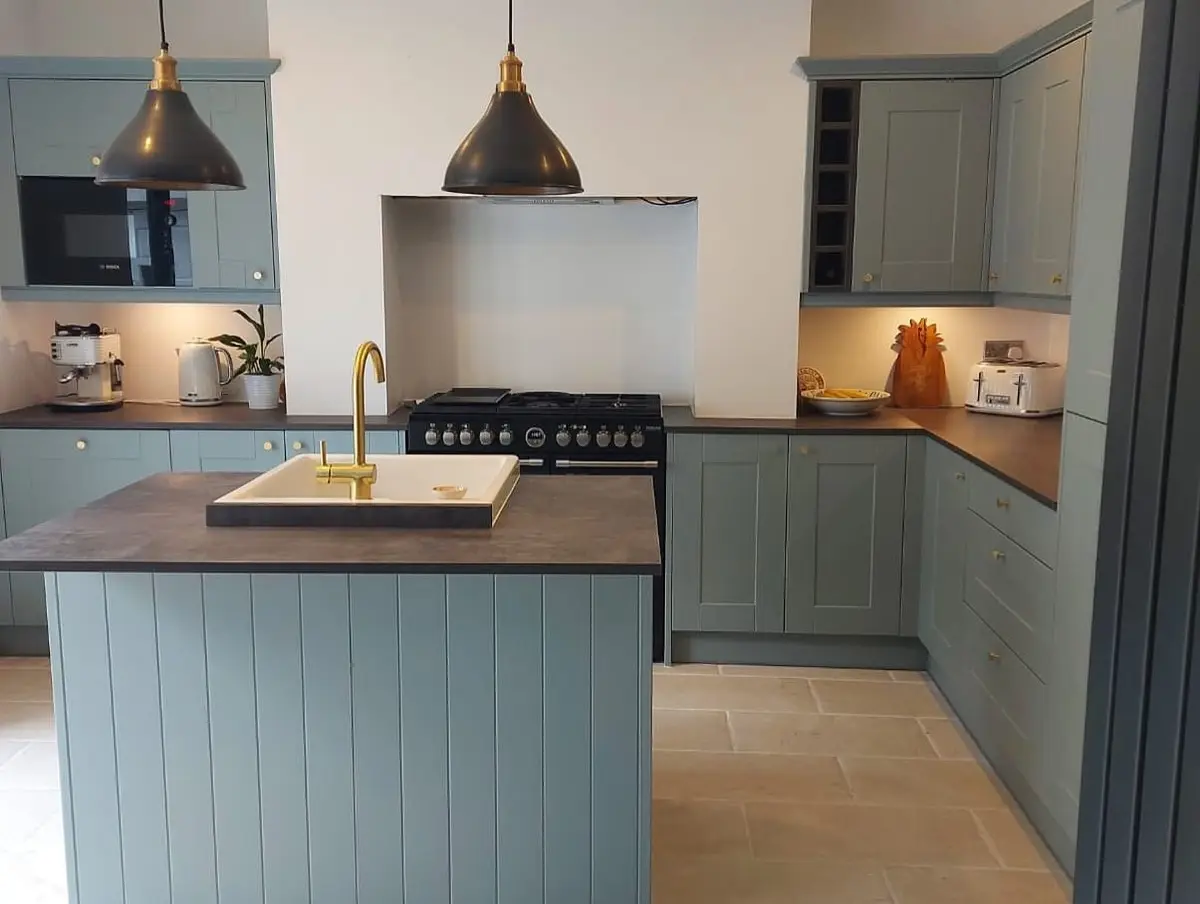 Blue-grey shaker island beneath black pendant lights