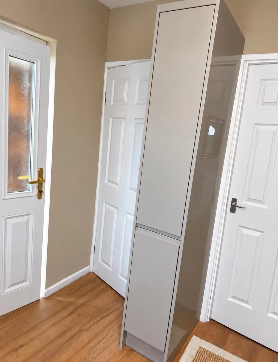 Tall grey handleless larder unit beside the kitchen door
