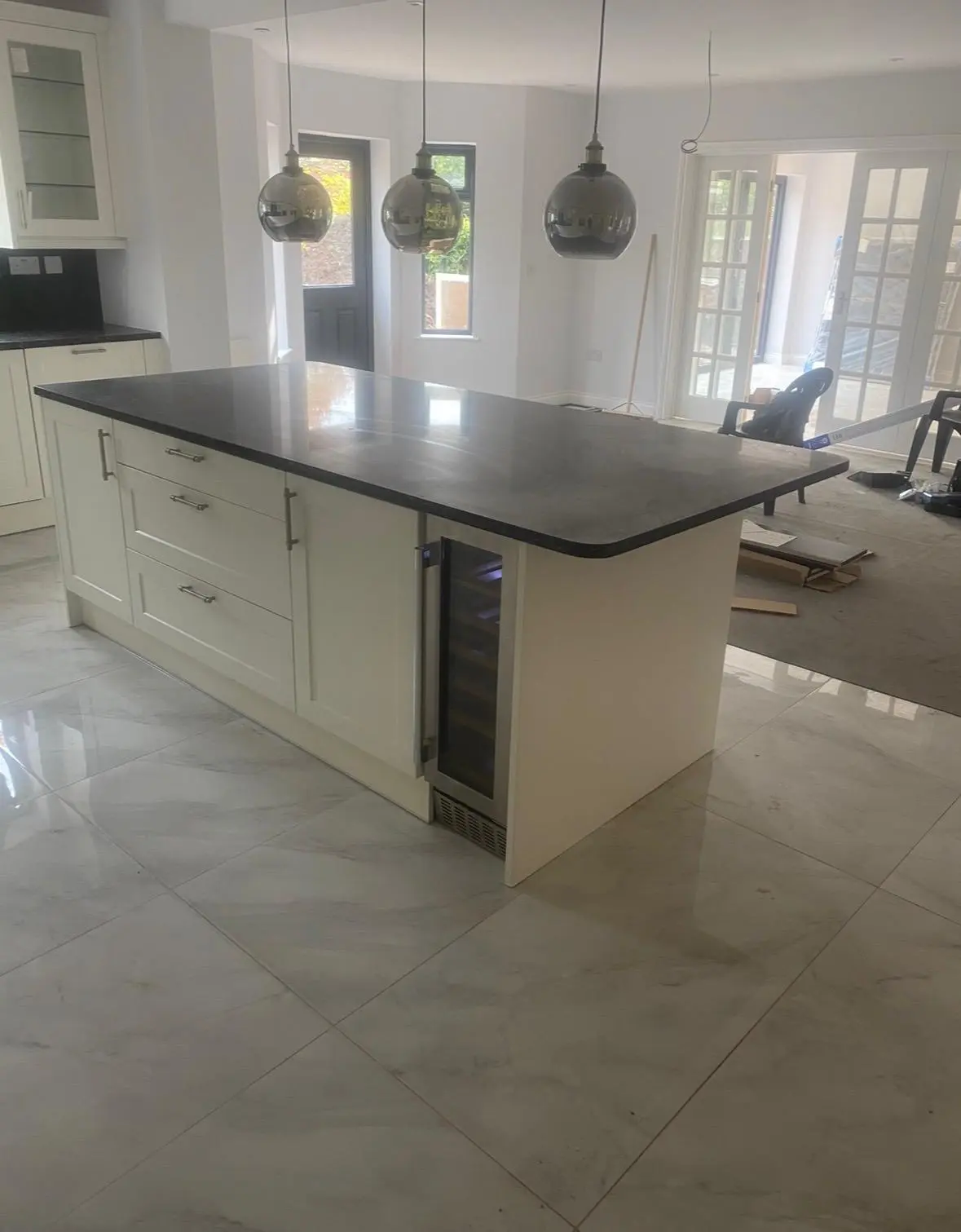 Cream shaker island with a wine cooler and black marble worktop