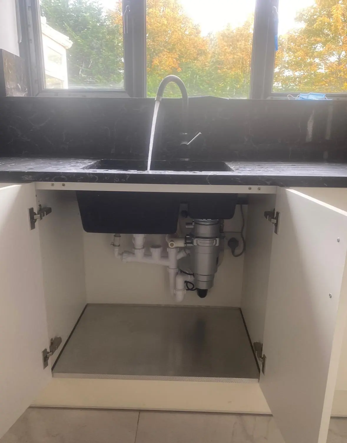 Black sink with the cupboard below open