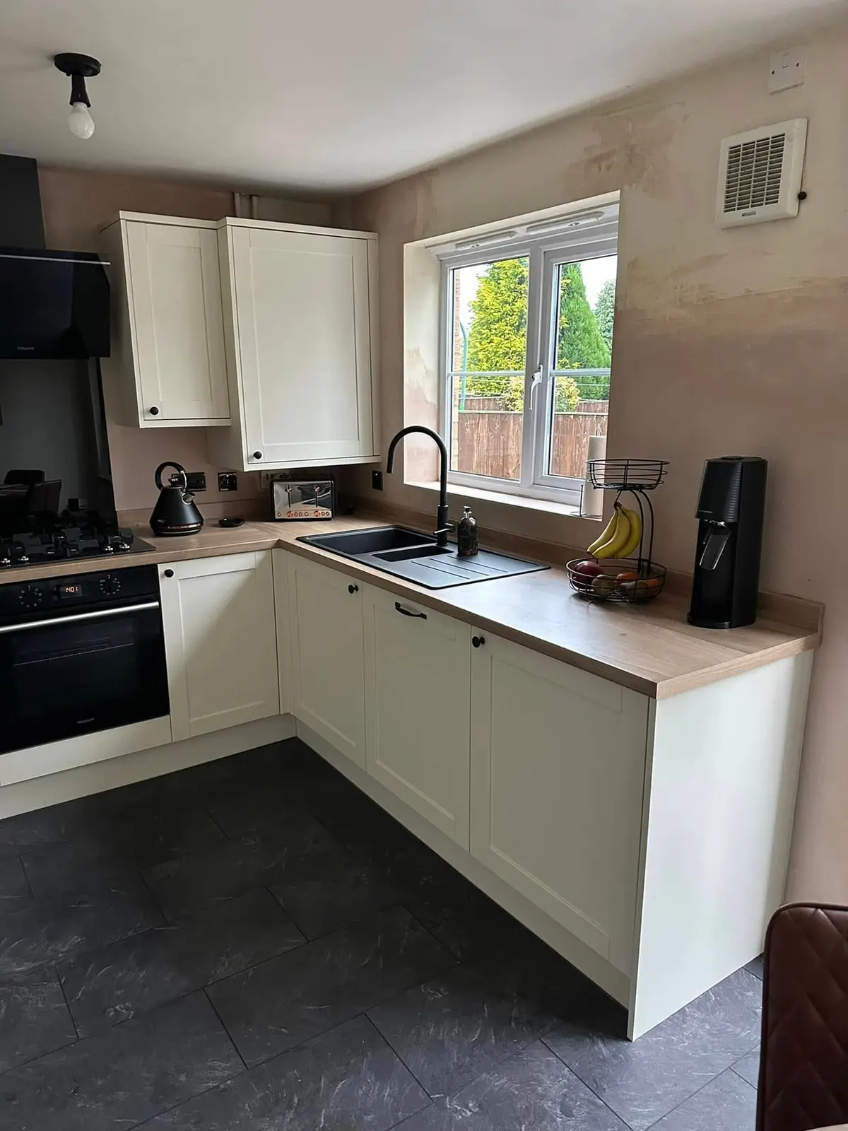 Cream shaker kitchen with black extractor and black appliances