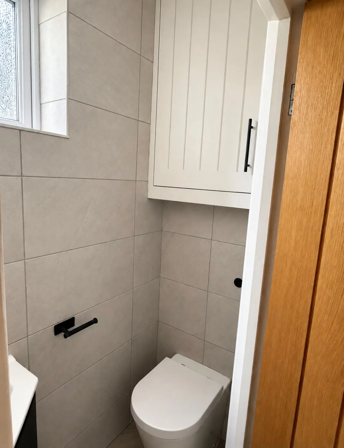 White farmhouse-style boiler cupboard above the WC