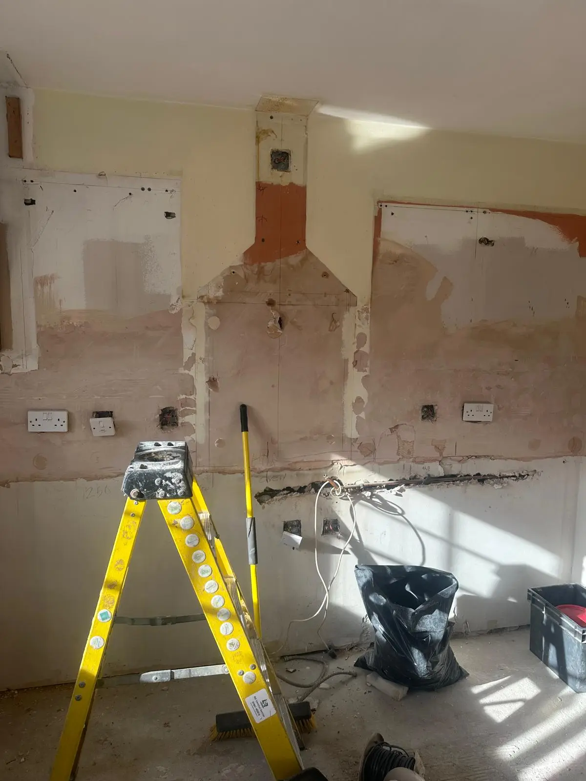 Kitchen stripped out, with a laser level set up for the new units