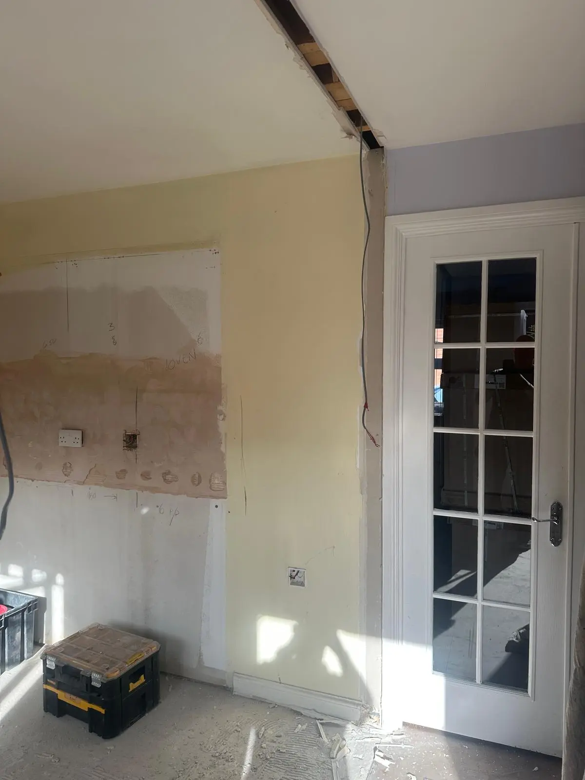 The stripped-out room beside the glazed door