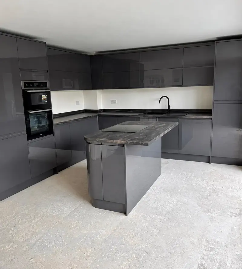 Graphite gloss handleless kitchen with an island, dark worktops and a built-in double oven