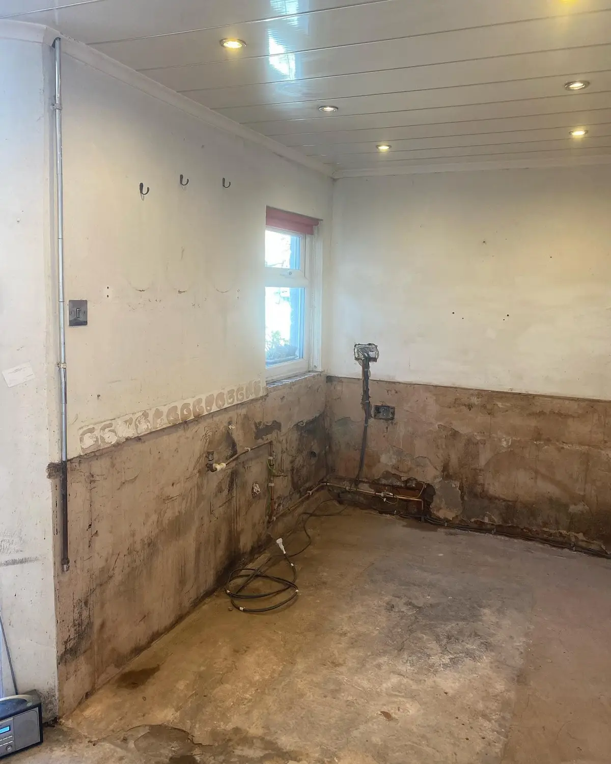 Stripped kitchen corner with capped services beneath the window