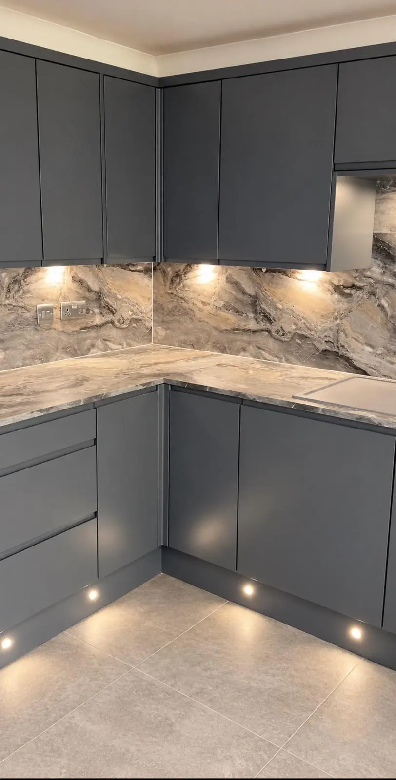 Lava grey corner run with under-cabinet lighting on the marble-effect wall panels and plinth lights