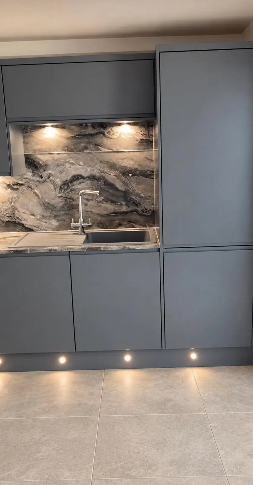 Sink run with lava grey wall units and a tall unit, plinth lights below
