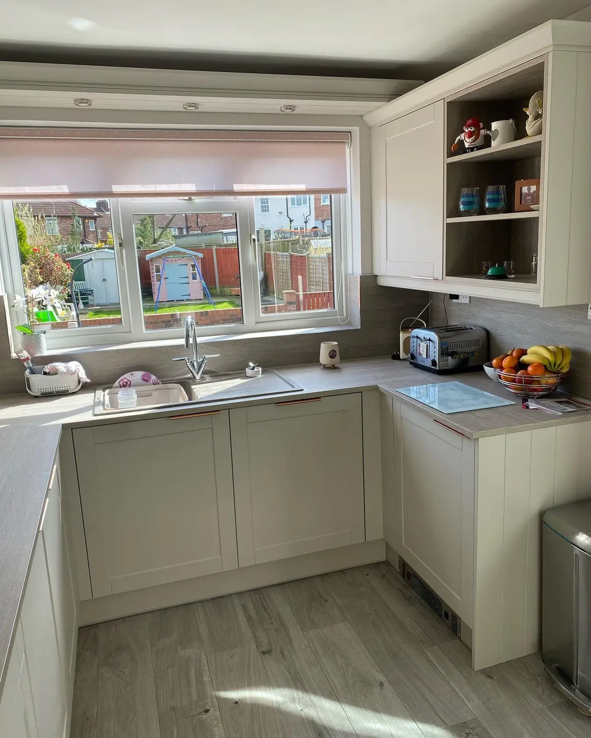 Light shaker sink run beneath a window with a view of the garden