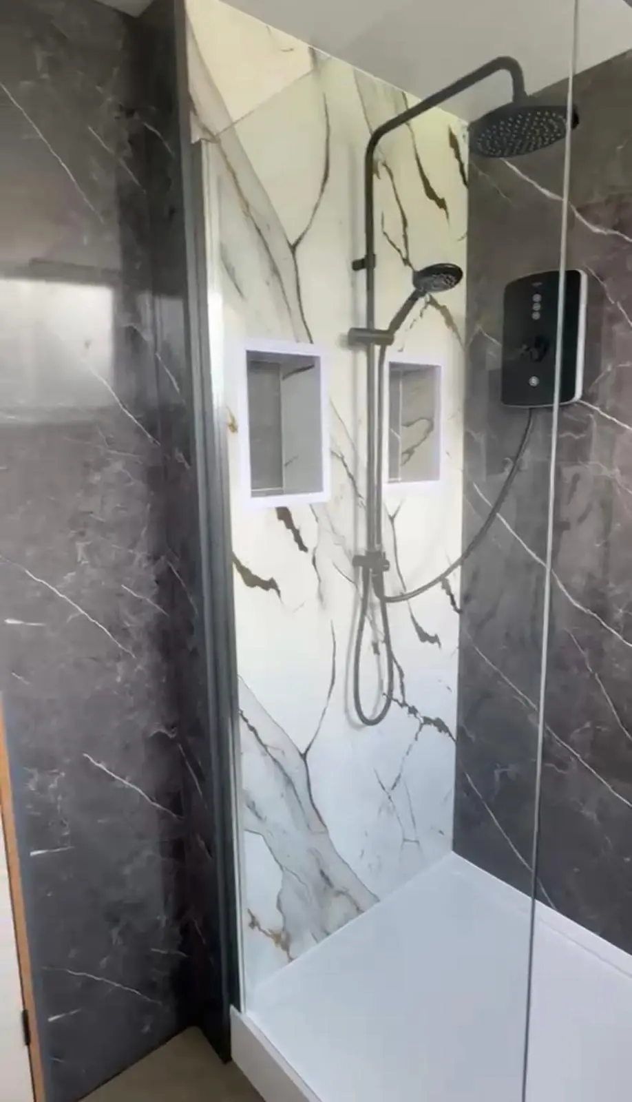 Walk-in shower with marble-effect panels and alcoves