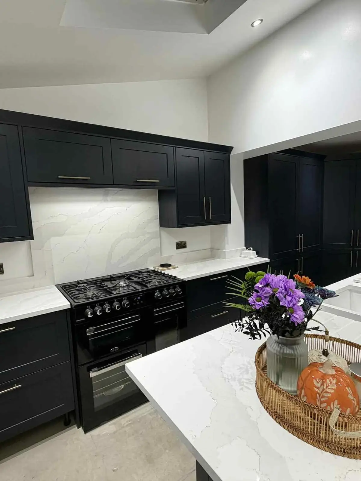 Navy shaker kitchen with range cooker and full-height quartz splashback in St Helens