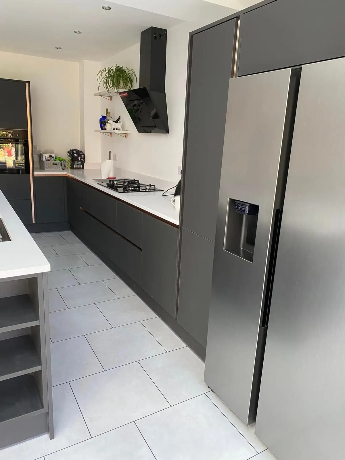Tall dark grey units and American fridge-freezer housing beside the island