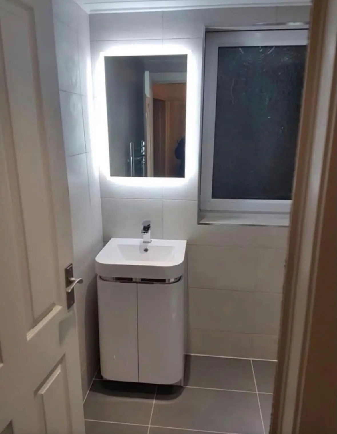 Floor-standing basin unit beneath an illuminated LED mirror