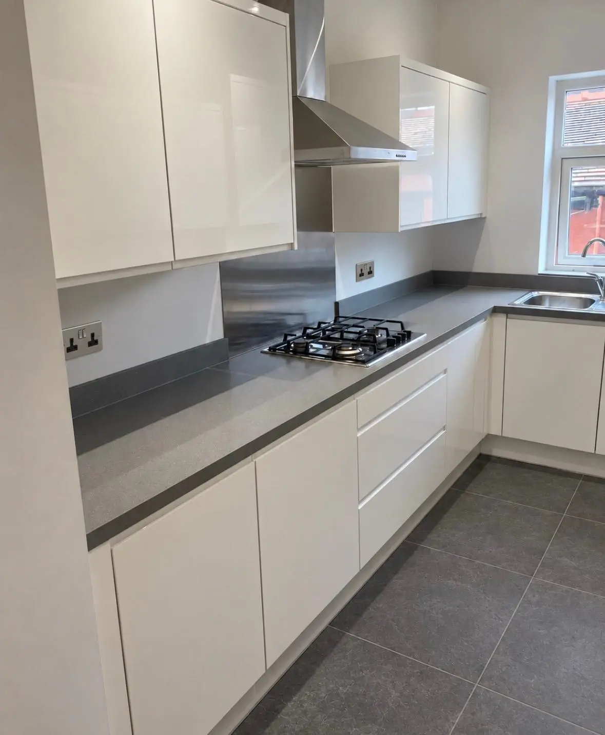 Gas hob and stainless extractor on the white handleless run