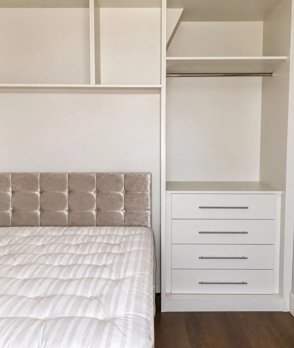 Drawer unit and hanging space inside the tall wardrobe beside the bed