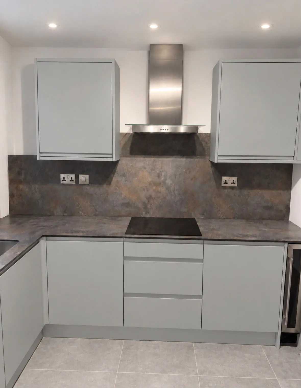 Hob run with a stainless chimney extractor between grey wall units