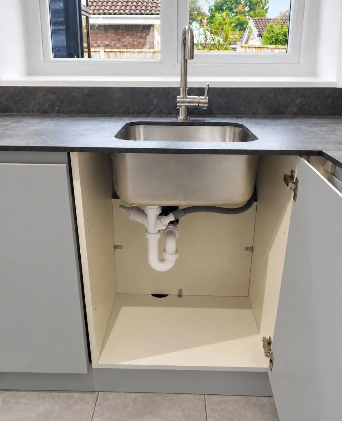 Undermount sink and waste, with the cupboard below open